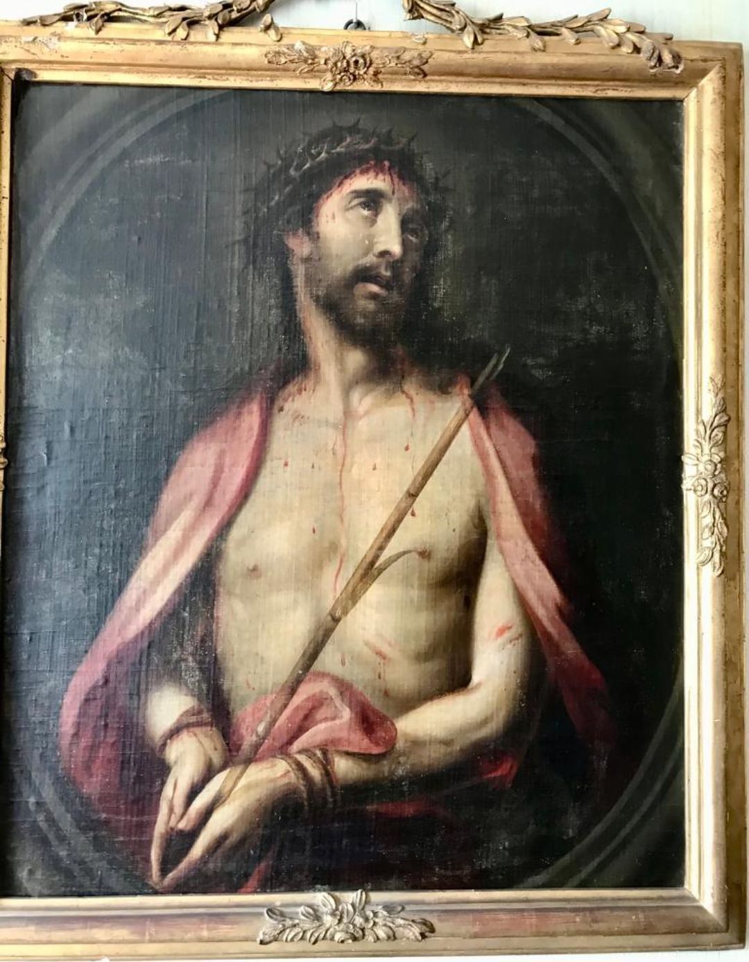 Un cuadro de Jesús con una corona de espinas está colgado en una pared.