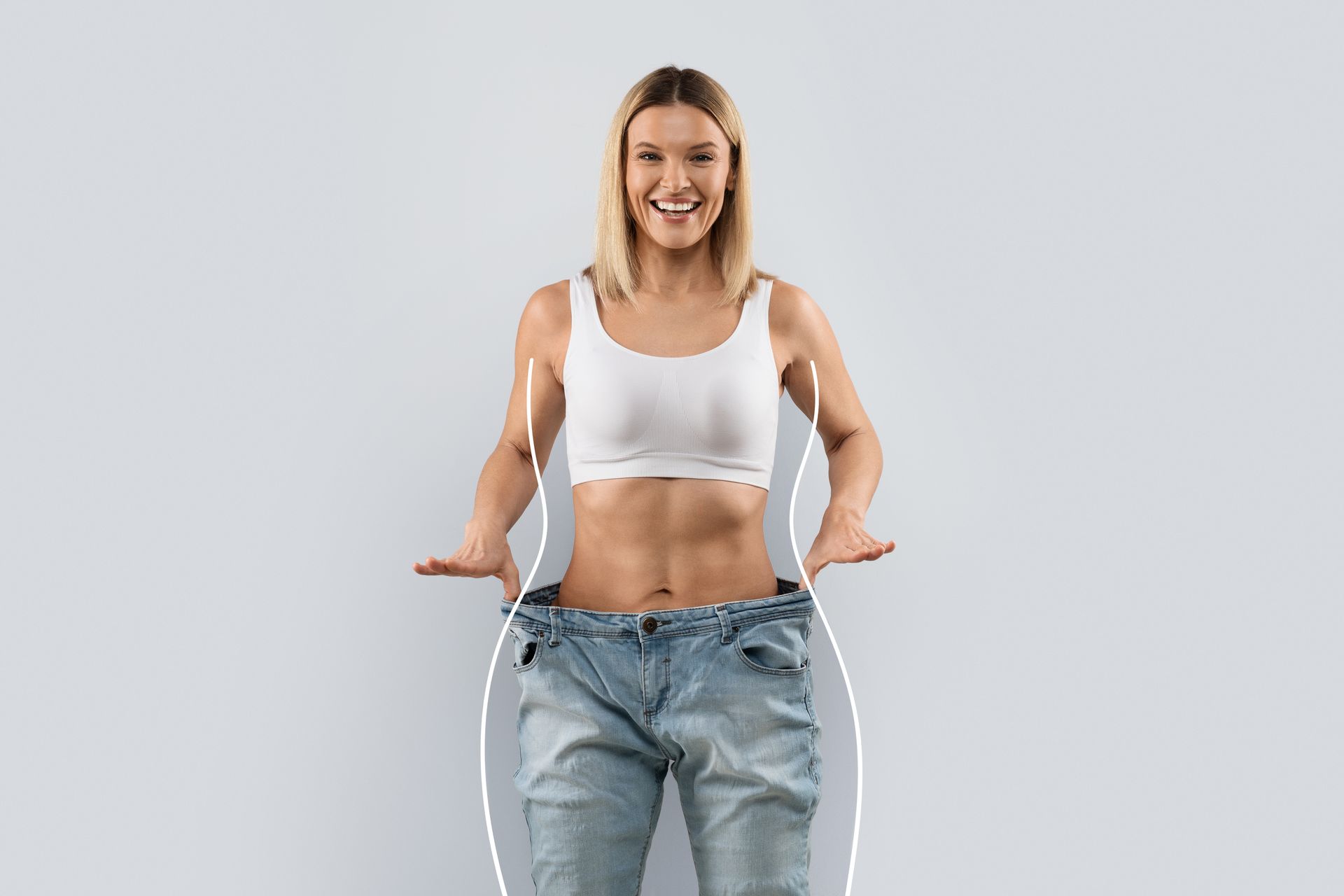 Une femme souriante qui porte un jean trop grand