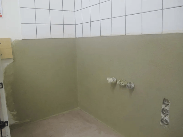 Ein Badezimmer mit gefliesten Wänden und einem Waschbecken.