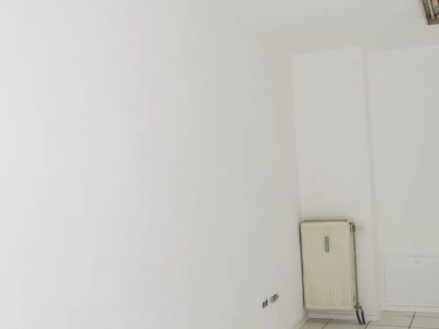 Ein leerer Raum mit weißen Wänden und einer Heizung in der Ecke.