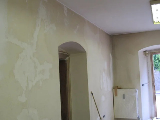 Ein Raum mit einer Tür und einem Wischmopp auf dem Boden.