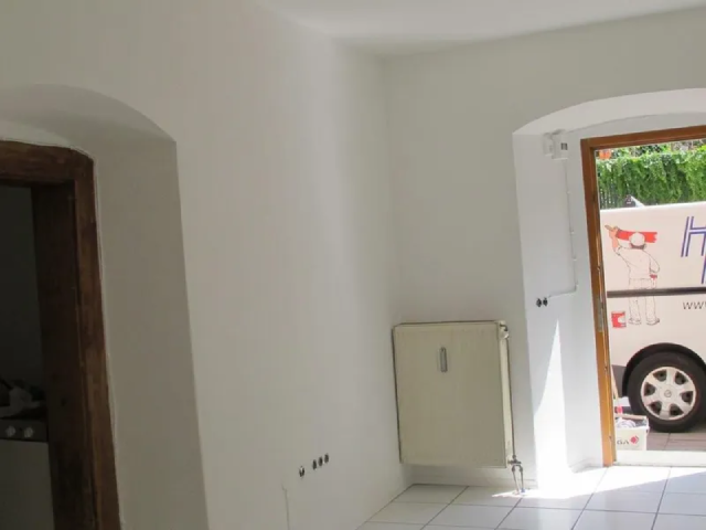 Ein weißer Lieferwagen mit dem Buchstaben H auf der Seite steht in einer Garage