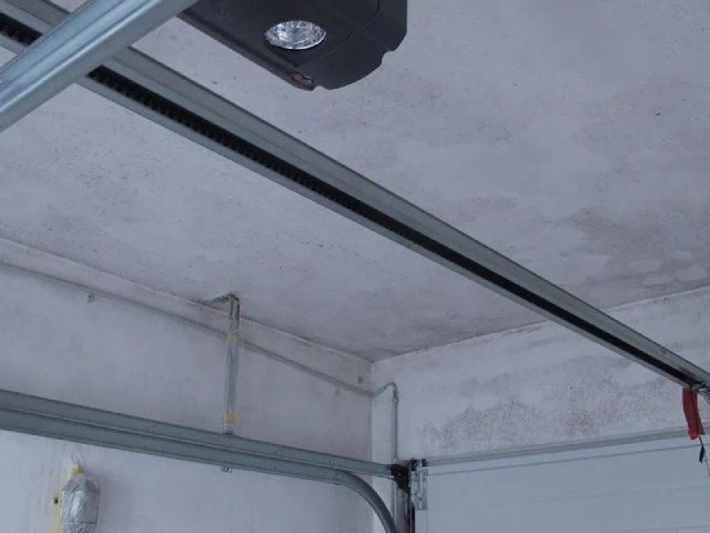 Ein Garagentoröffner hängt von der Decke einer Garage.