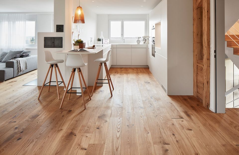 Eine Küche mit Holzboden und weissen Schränken