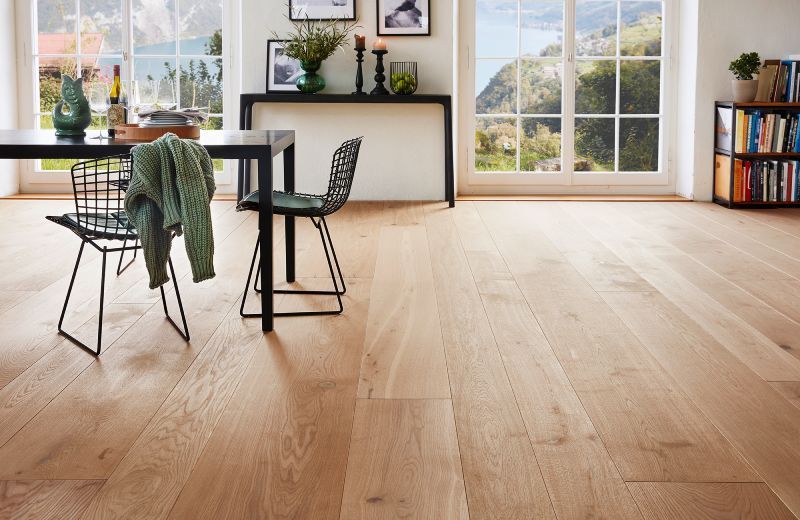 Ein Esszimmer mit Holzboden und Tisch und Stühlen