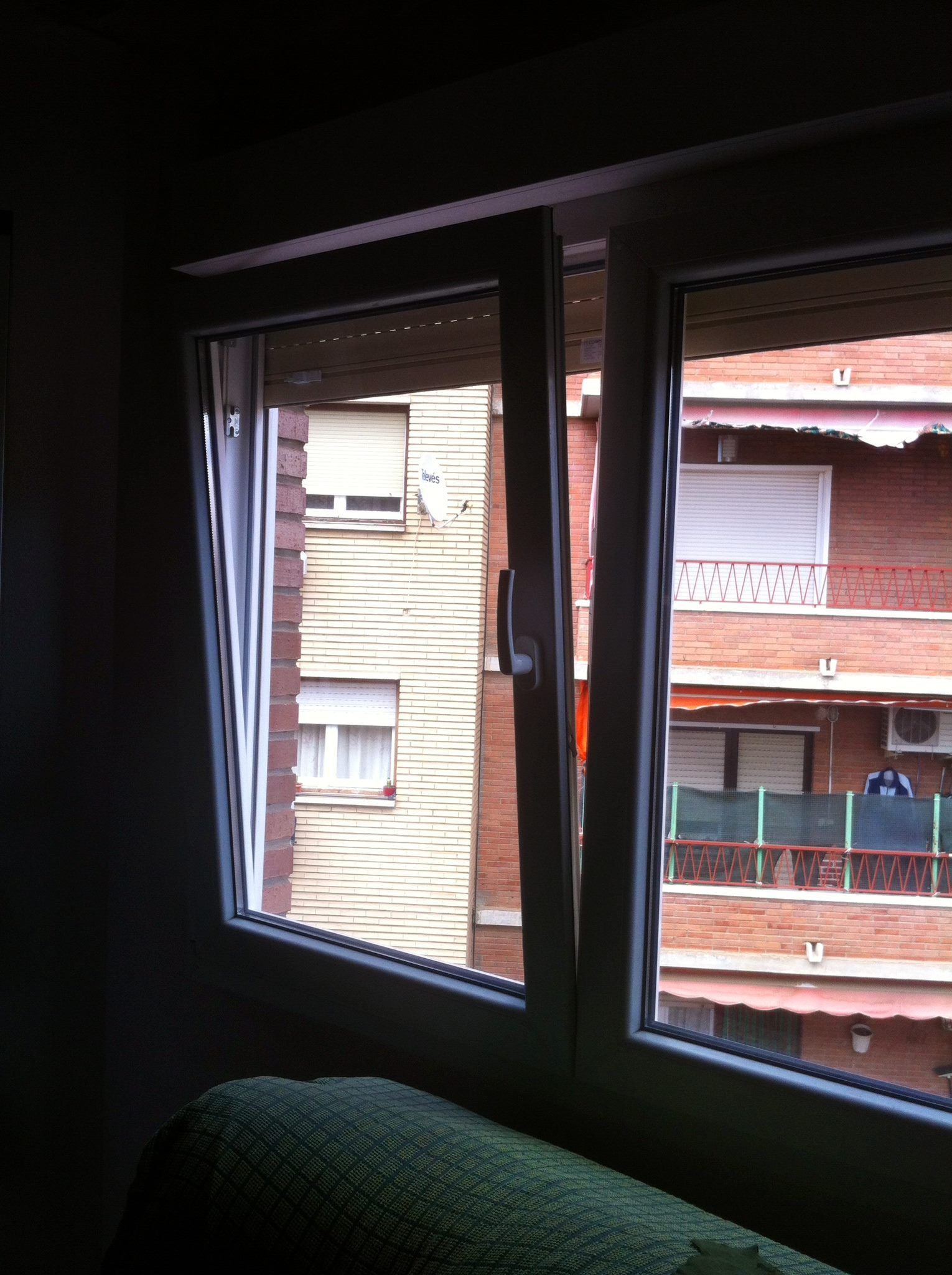 Una ventana con vista a un edificio de ladrillo