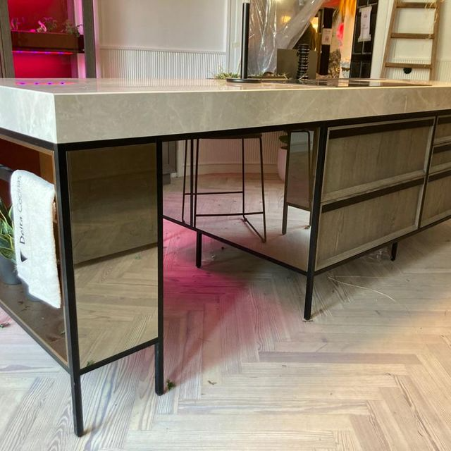 Una mesa grande con un espejo al costado en una habitación.