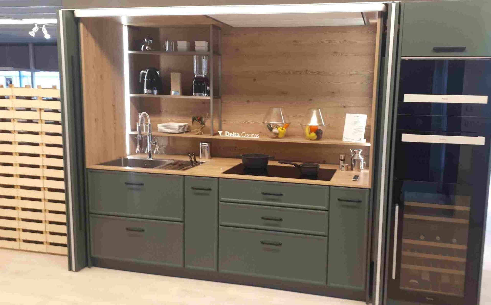 Una cocina con gabinetes verdes y un enfriador de vinos.