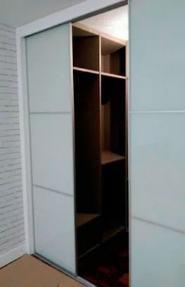 Un vestidor con puertas corredizas de vidrio en un dormitorio.