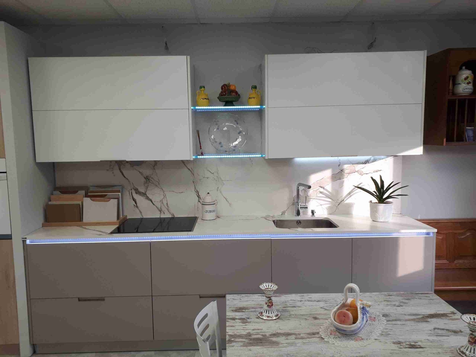 Una cocina con una mesa y sillas y un fregadero.