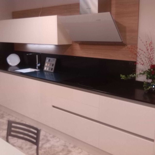 Una cocina con gabinetes blancos y encimeras negras.