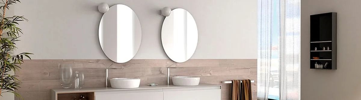 Un baño con dos lavabos y dos espejos en la pared.