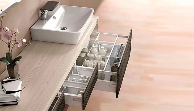 Un tocador de baño con lavabo y cajones abiertos.
