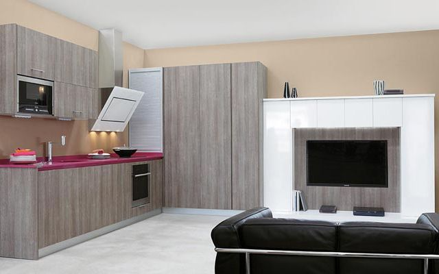 Una cocina con un sofá y un televisor en la pared.