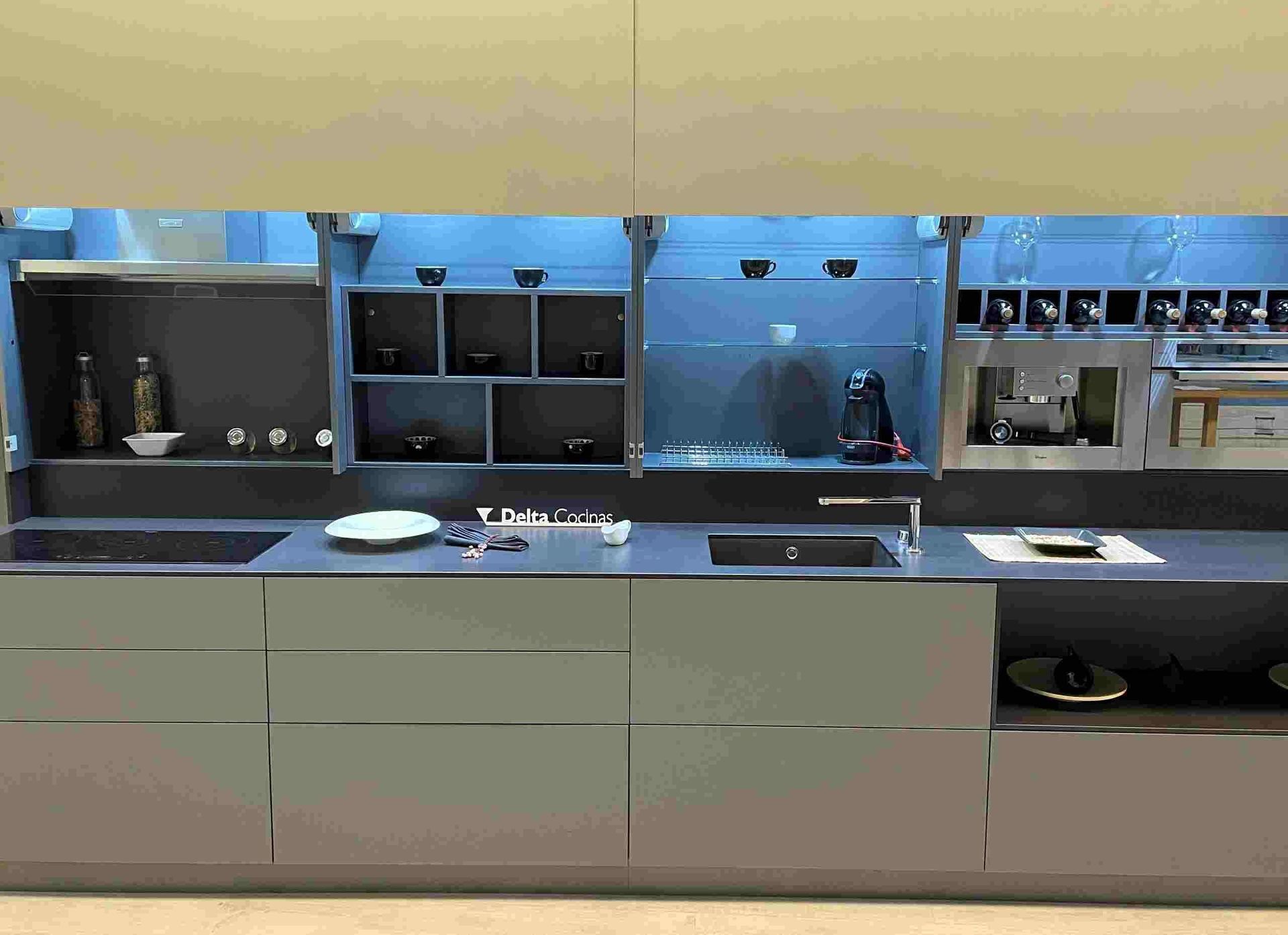 Una cocina con fregadero, estufa y estantes.