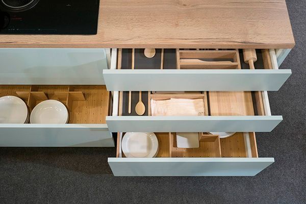 Una cocina con muchos cajones llenos de platos y utensilios.