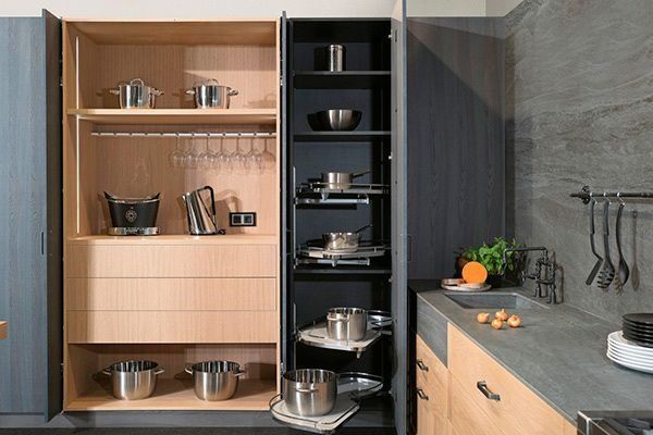 Una cocina con una despensa llena de ollas y sartenes.