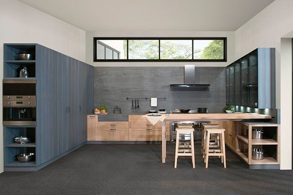 Una cocina con gabinetes azules y encimeras de madera.