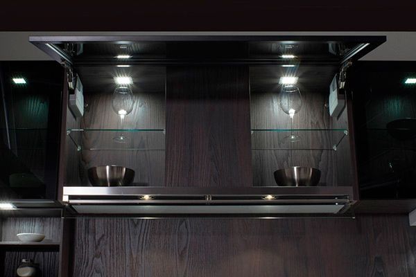 Una cocina con electrodomésticos de acero inoxidable y estantes de vidrio.