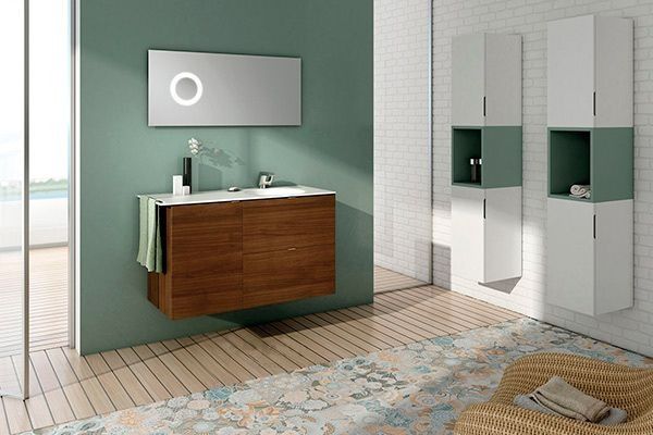 Un baño con lavabo, espejo, armarios y una silla.