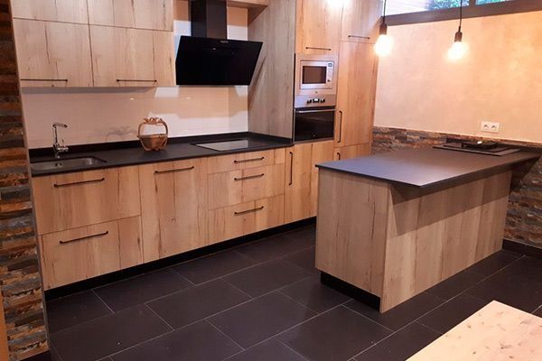 Una cocina con gabinetes de madera y una encimera negra.