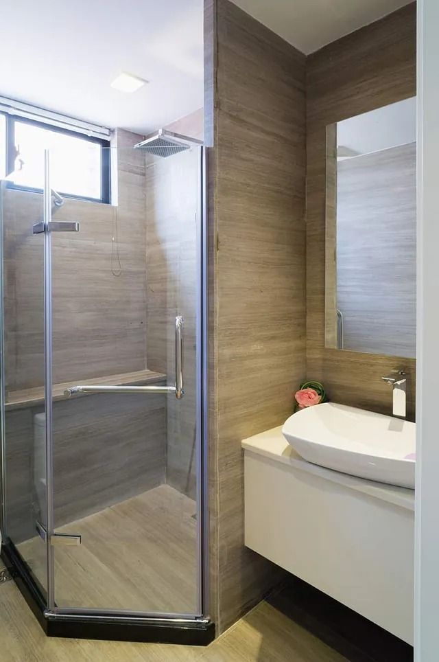 Un baño con ducha, lavabo y espejo.