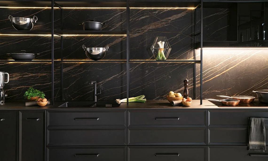 Una cocina con gabinetes negros, un fregadero y un horno de estufa.