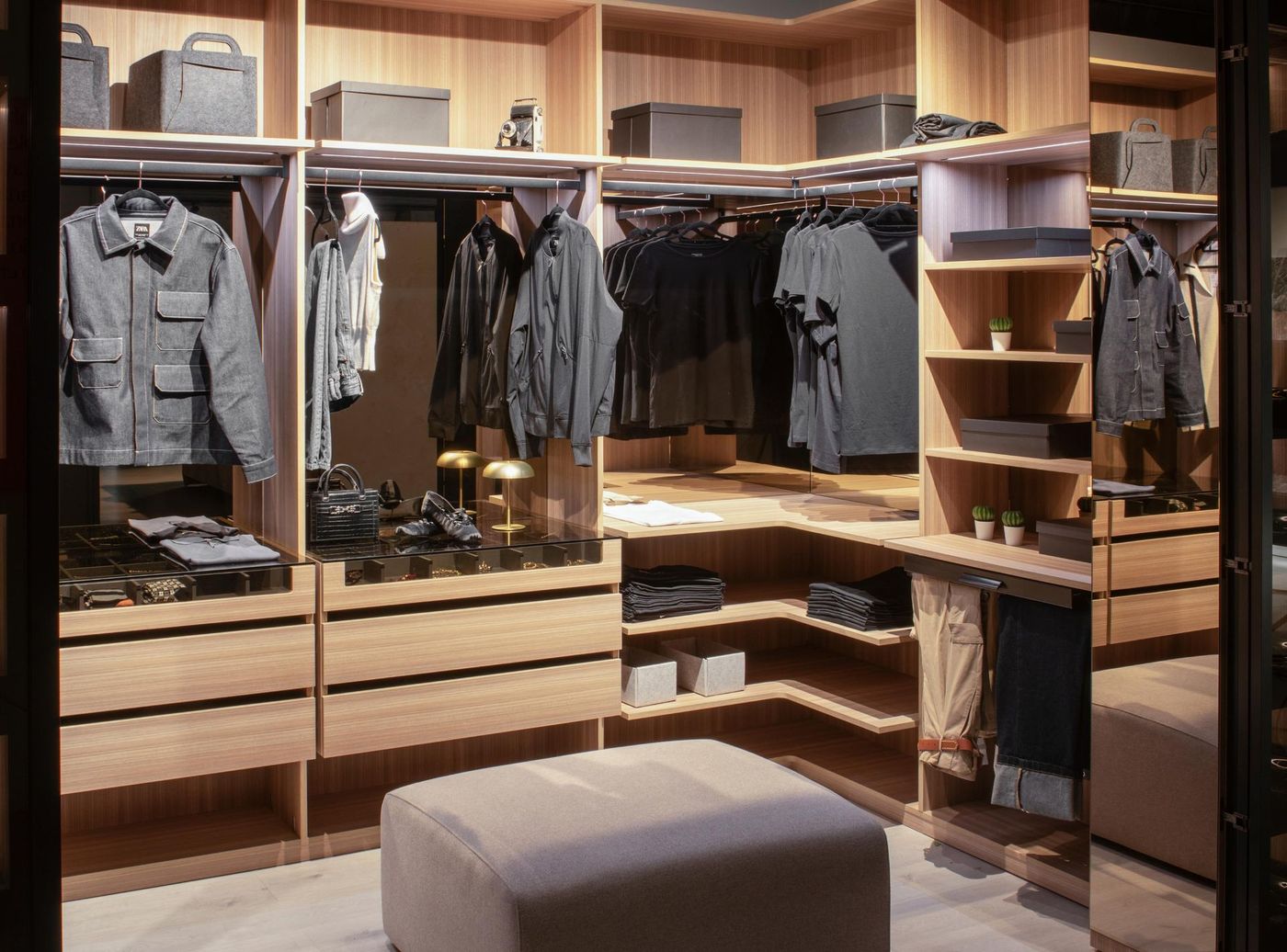 Un gran vestidor con muchos estantes y cajones llenos de ropa.