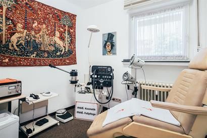 Ein Raum mit einem Stuhl und einem Wandteppich an der Wand.