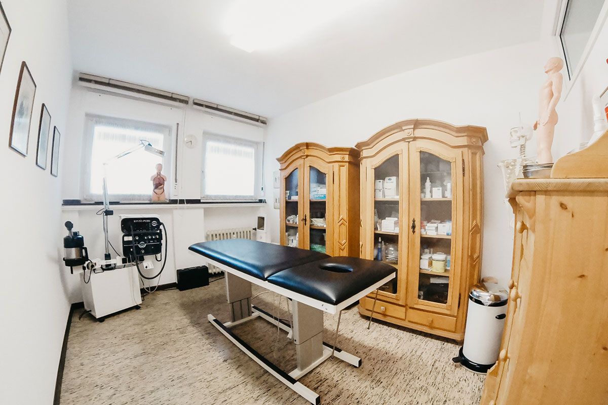 Eine Arztpraxis mit Tisch und Schränken