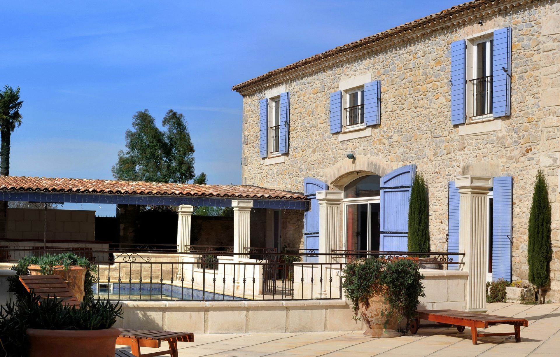 Grande maison en pierre avec volets bleus