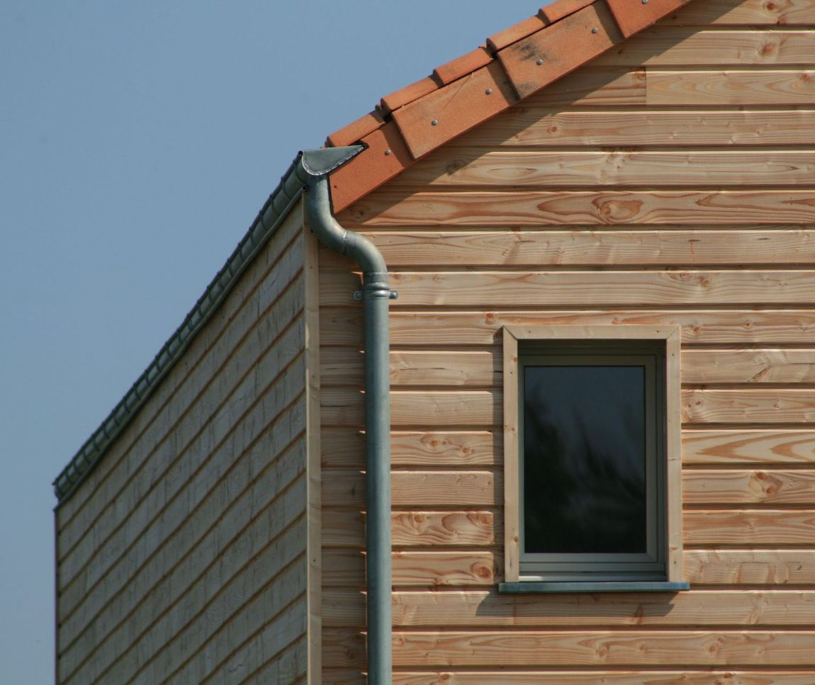 Maison avec un bardage en bois et des tuiles