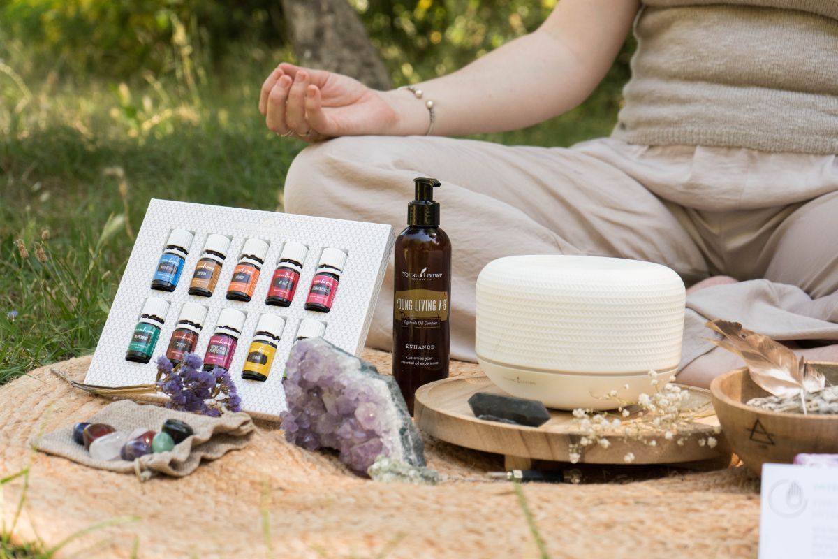 Productos de bienestar expuestos al aire libre junto a una persona sentada sobre una manta de picnic.