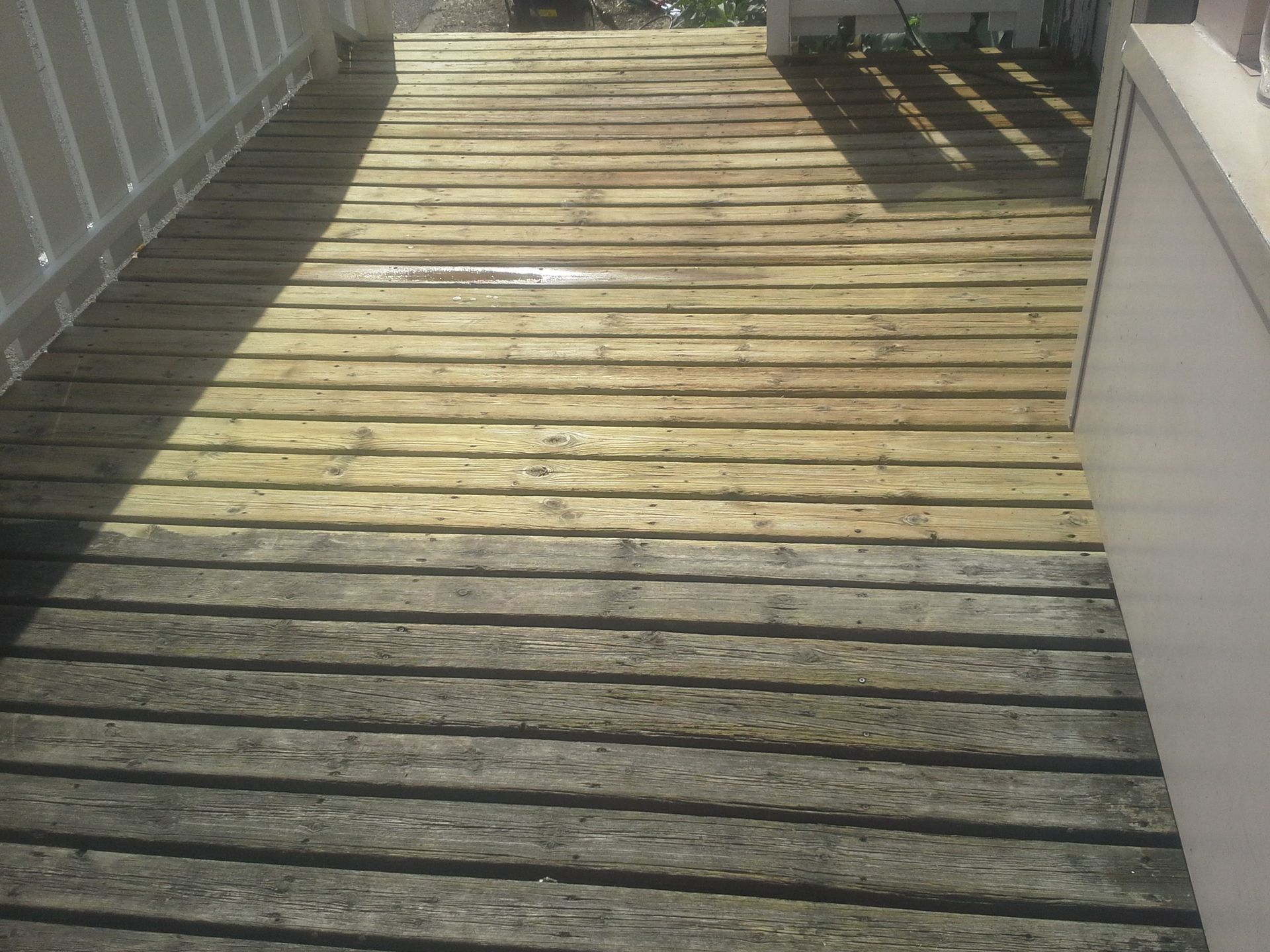 Terrasse en lames de bois massif en cours de nettoyage