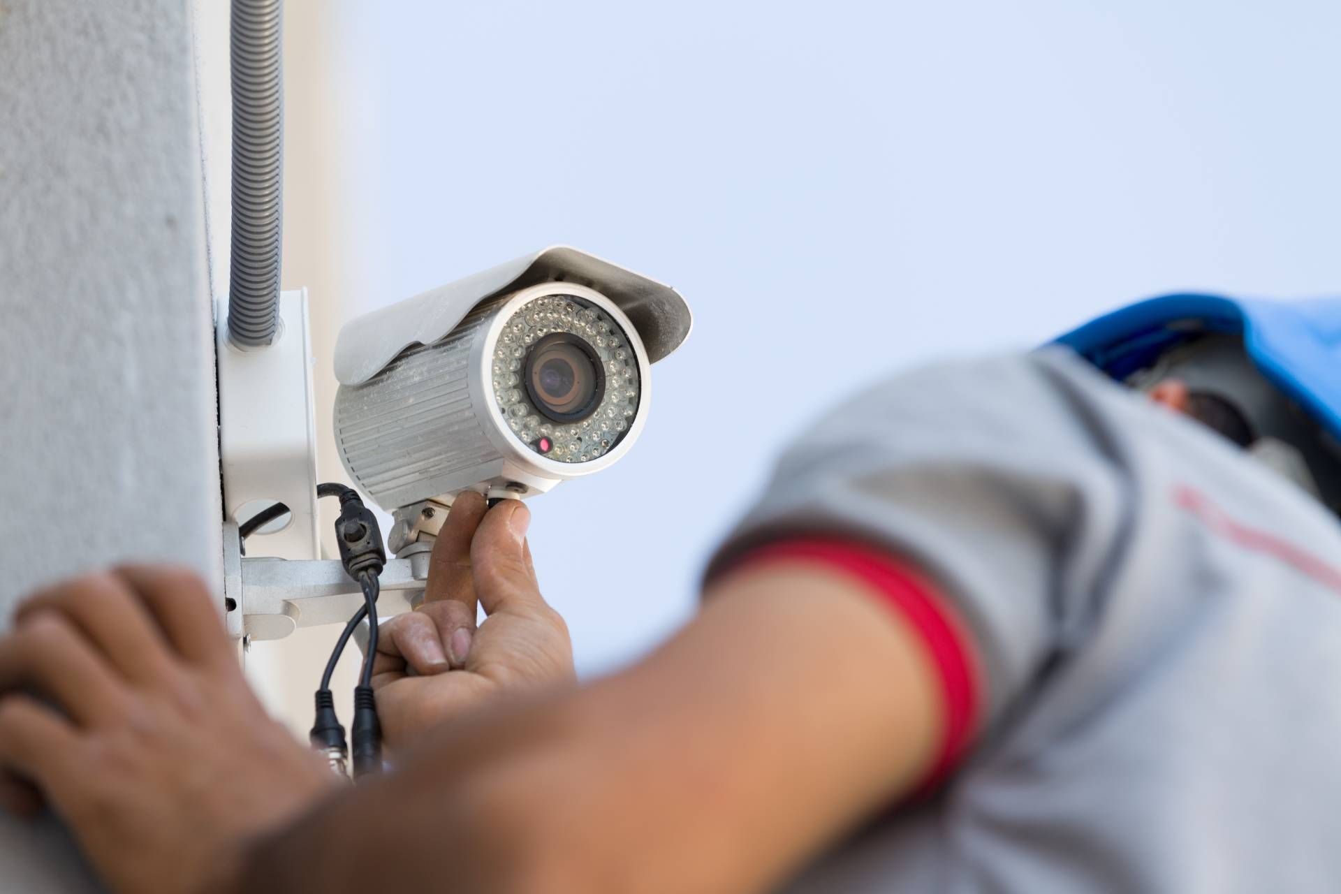 Elektriker arbeitet an einer Überwachungskamera an einem Haus
