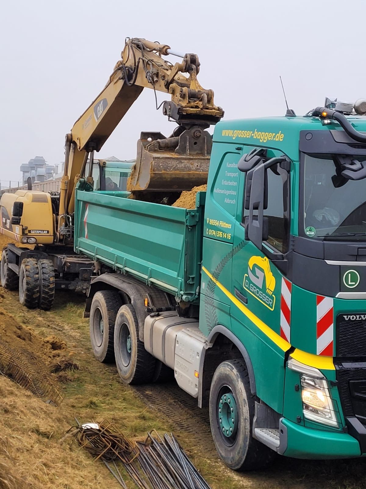 Bagger belädt Transporter