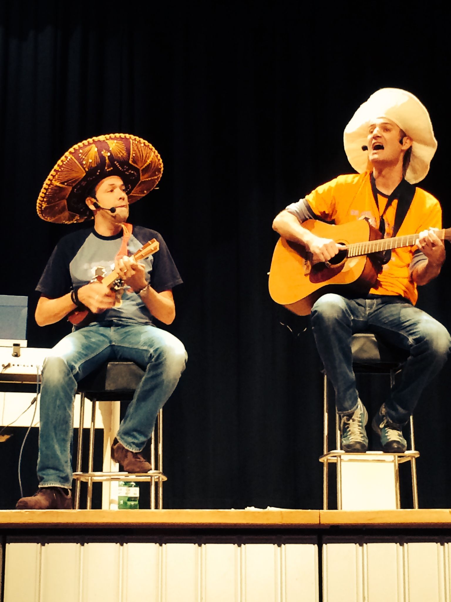 Ein Lehrer hilft zwei Kindern in einem Klassenzimmer bei ihren Hausaufgaben.