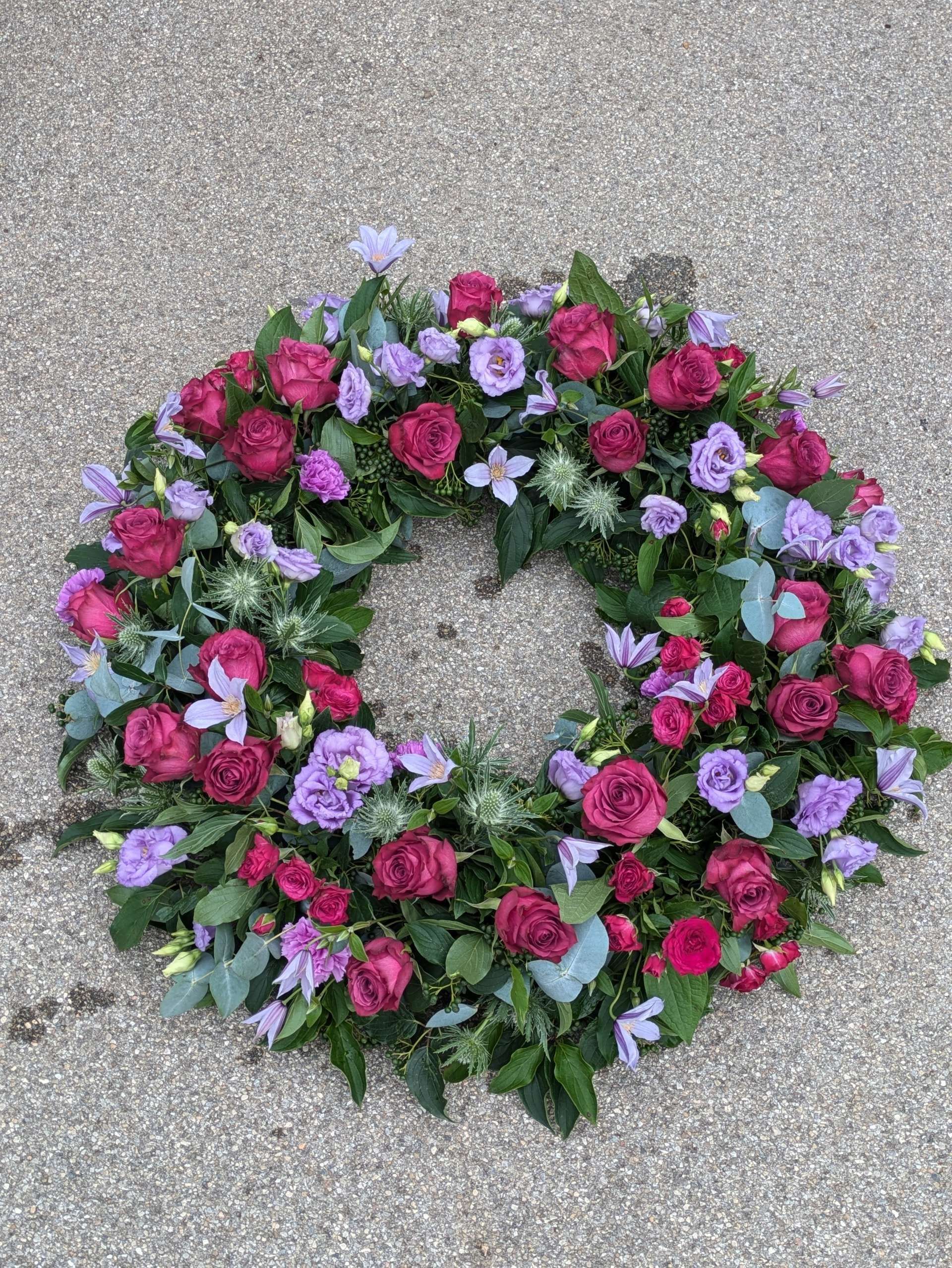 Runder Blumenstrauß mit gemischten magenta und lila Blüten auf einer Oberfläche
