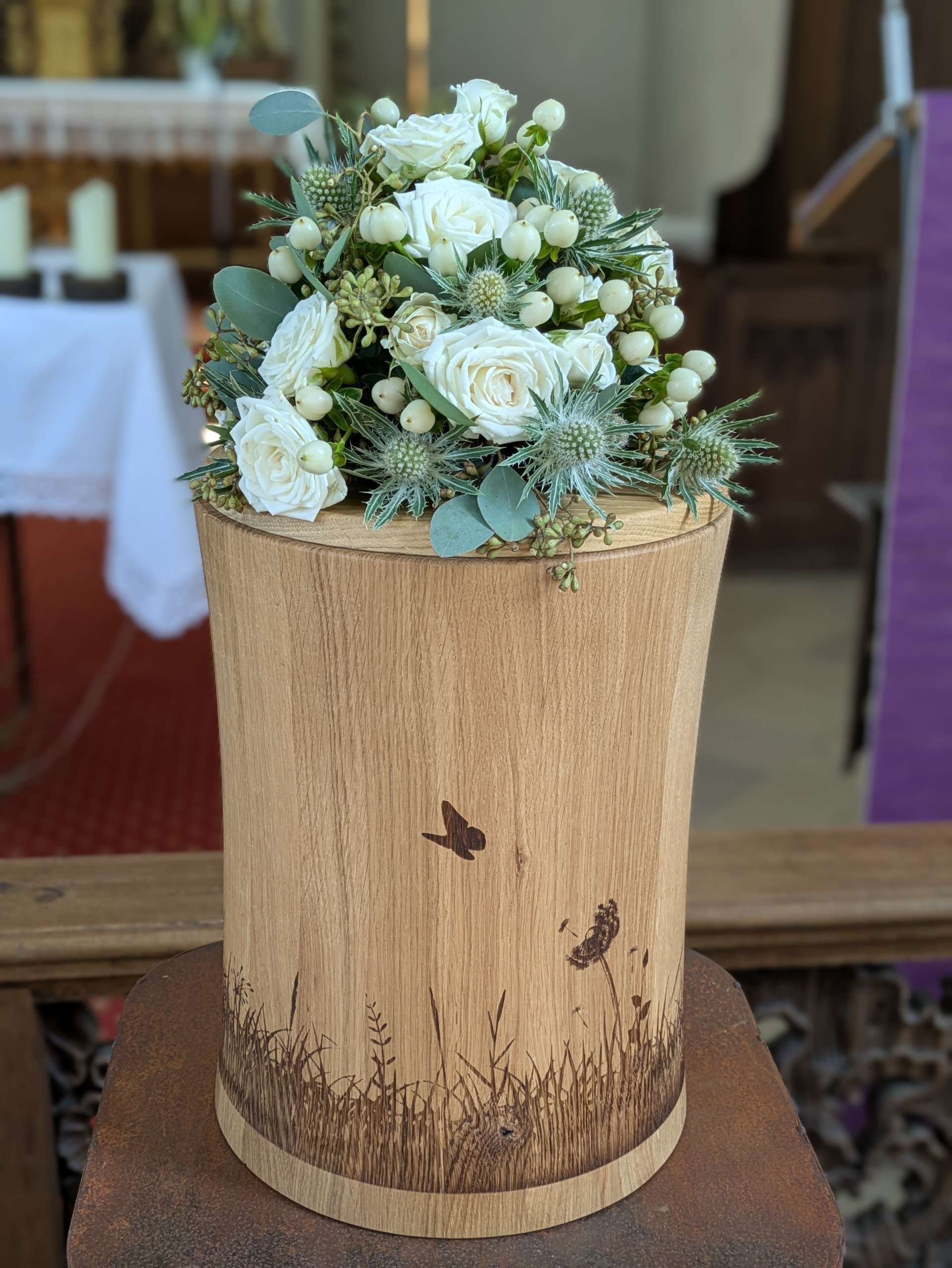 Runder Blumenstrauß mit dicht gebundenen Rosen und Blüten bei einer Veranstaltung