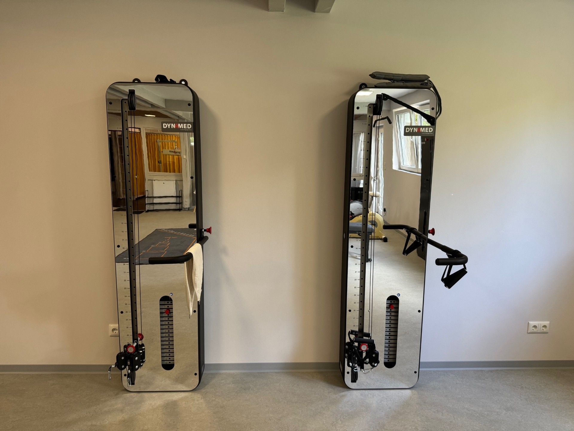 Zwei silberne Kabelmaschinen, die an einer beigen Wand in einem Raum montiert sind.