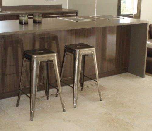 Îlot de cuisine moderne avec deux tabourets de bar en métal et un coin repas.