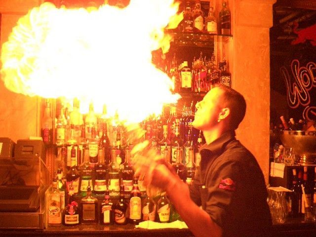 Ein Barkeeper bläst Flammen aus seinem Mund