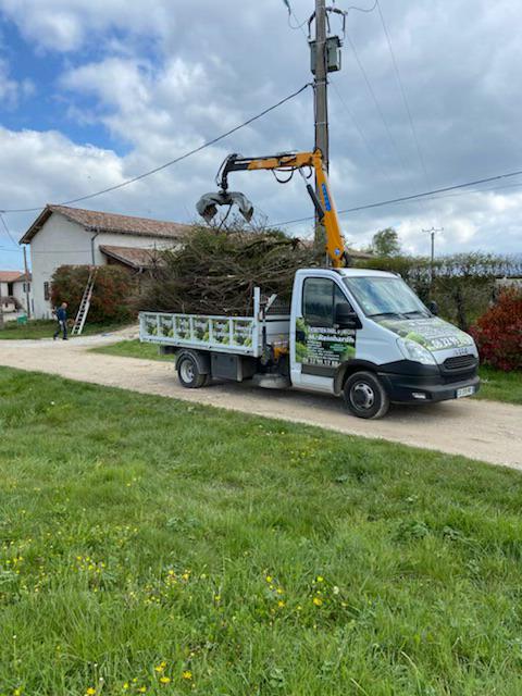Le véhicule d'intervention à Civrieux de notre entreprise d'élagage qui avec son bras garnit sa remorque de branches