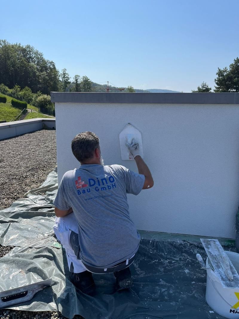 Arbeiter verputzt eine Aussenmauer