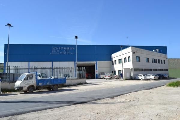 Un camión azul está estacionado frente a un gran edificio.