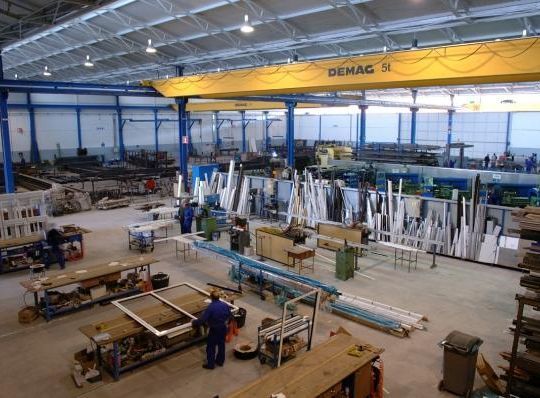 Un gran almacén con una grúa amarilla que dice dehac.