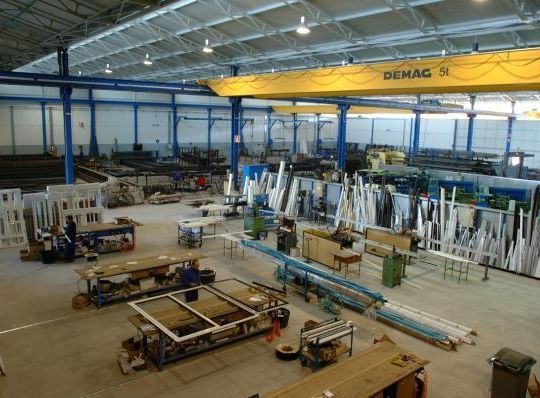 Un gran almacén con una grúa amarilla que dice demag