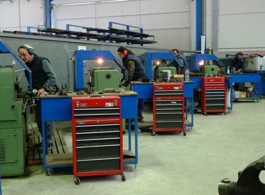 Un grupo de hombres está trabajando en máquinas en una fábrica.