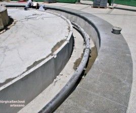 Se está construyendo una fuente de hormigón de la que sale una manguera.