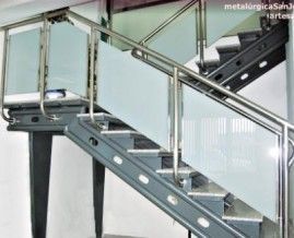 Una escalera con barandilla de acero inoxidable y escalones de cristal.